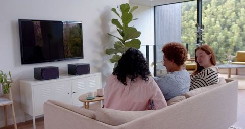 Diverse Female Friends Watching TV in Minimalist Living Room