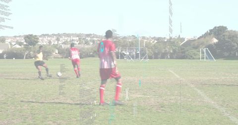 Youth soccer players dribbling toward sideline on sunny community pitch showing teamwork