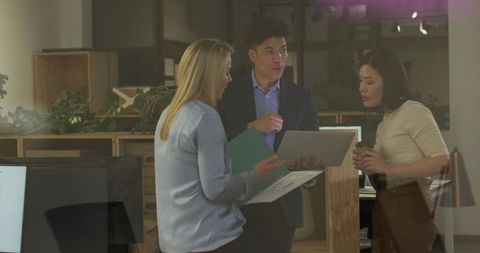 Diverse team engaged in office discussion in modern workplace