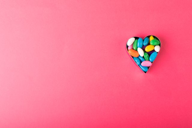 Heart Shaped Container with Colorful Candies on Pink Background - Download Free Stock Photos Pikwizard.com