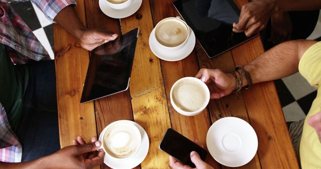 Group of friends using mobile phone and digital tablet while having cup of coffee in cafe 4k