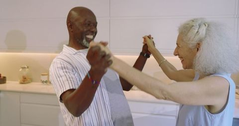 Senior couple dancing in modern kitchen