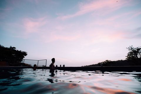 Silhouette of People Relaxing in Pool During Sunset