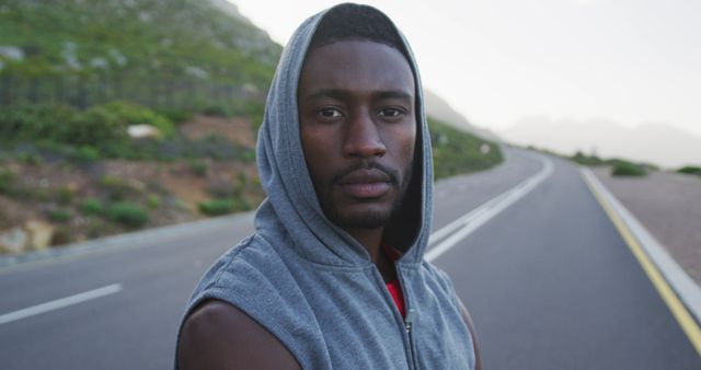 Portrait of african american man wearing a hoodie standing on the road. fitness and healthy lifestyle concept