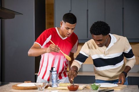 Diverse Friends Making Homemade Pizza in Modern Kitchen