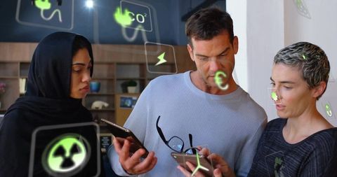 Team analyzing eco icons on digital devices in modern office