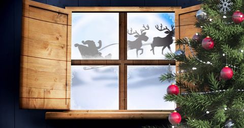 Santa Claus Sleigh with Reindeer Seen Through Frosty Window
