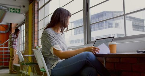 Businesswoman Reading Documents at Modern Office Desk - Download Free Stock Images Pikwizard.com