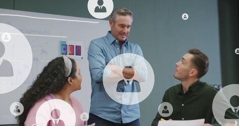 Diverse Colleagues Collaborating in Modern Office with Virtual Icons