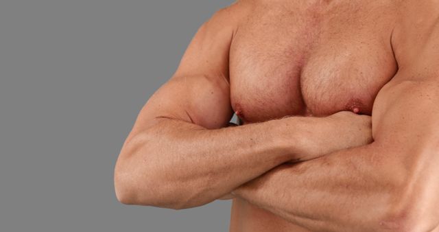 A Caucasian middle-aged man's torso is shown focusing on his muscular arms and chest, with copy space. His physique highlights fitness and strength, often associated with regular exercise and bodybuilding.