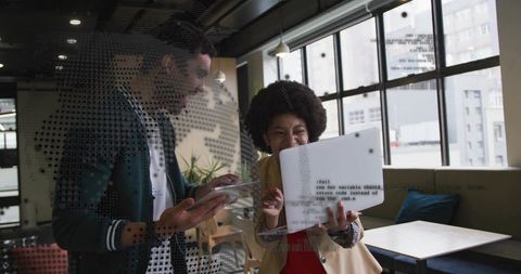 Collaborative Tech Team Sharing Code on Laptop in Modern Urban Coworking Workspace