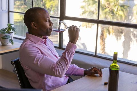 Man Enjoying Wine in Modern Tasting Room by Sunlit Window