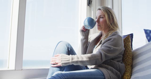 Woman Relaxing by Window with Coffee Cup - Download Free Stock Images Pikwizard.com