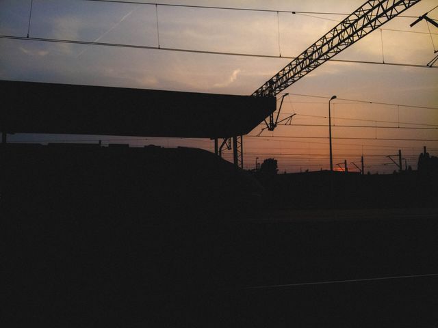 Sunset Silhouette of Train Station with Overhead Lines - Download Free Stock Photos Pikwizard.com