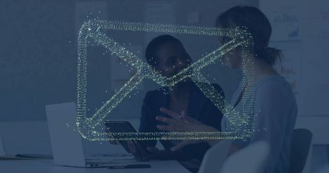 Two professionals collaborating with envelope hologram during boardroom meeting