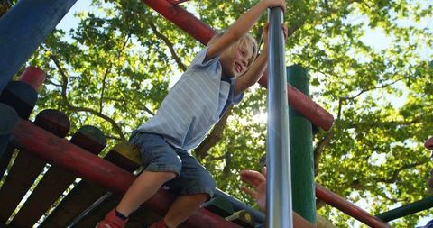 Joyful Child Climbing at Playground with Parental Support