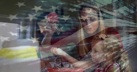 Mother and daughters crafting ornaments with patriotic digital design