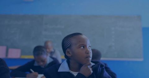 Thoughtful schoolgirl in uniform resting chin on hand, gazing during classroom lesson