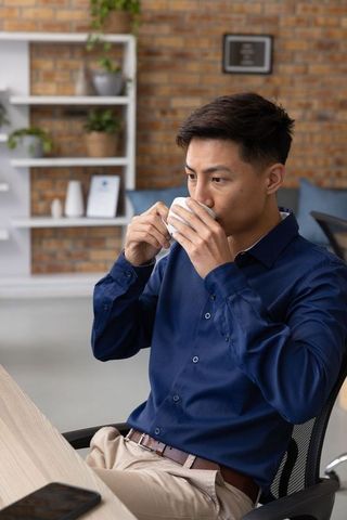 Male Professional Relaxing in Office with Coffee