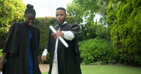 Graduates Celebrating Success Outdoors in Garden Setting