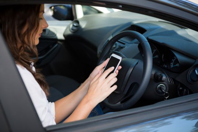 Woman using mobile phone while driving, highlighting issue of distracted driving. Suitable for campaigns on road safety, responsible driving, and technology impact on daily life. Can be used in articles, ads, or educational materials addressing driving laws and health risks.