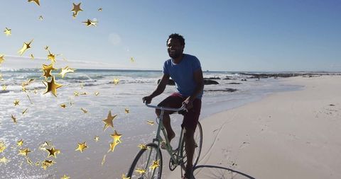 Man Cycling Along Sandy Beach with Star Reflections