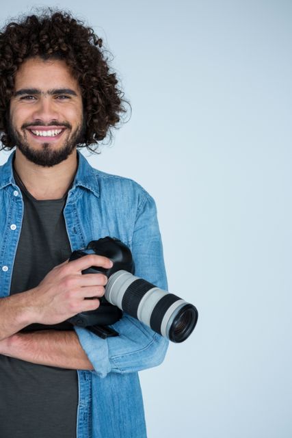 Portrait of happy male photographer standing in studio