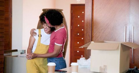 Young Women Dancing Cheerfully Together in New Home