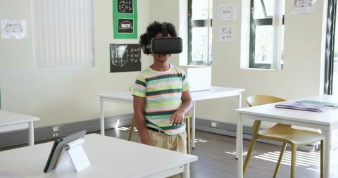 African American Child Exploring Virtual Reality Headset in Classroom Learning Environment