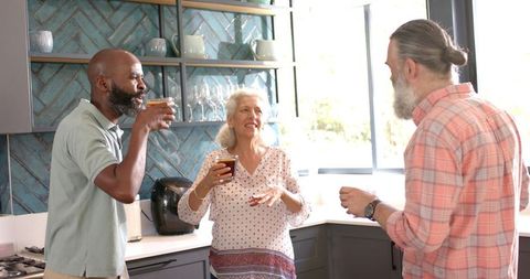 Senior Friends Enjoying Coffee and Laughter in Modern Kitchen