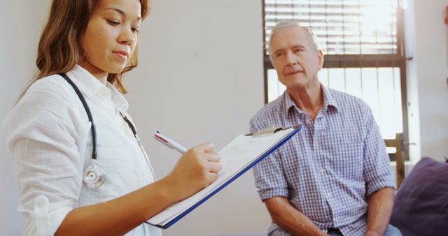 Doctor Taking Notes While Senior Patient Listens in Medical Office - Download Free Stock Images Pikwizard.com