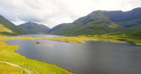 Transparent Lake with Lush Mountain Scenery at Sunrise
