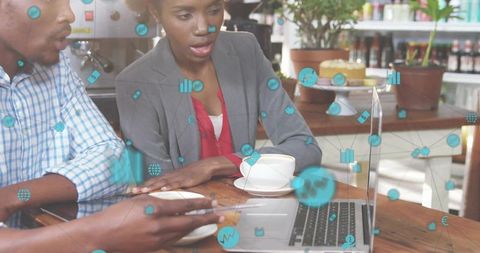 Professional Colleagues Analyzing Data on Laptop at Cafe Table