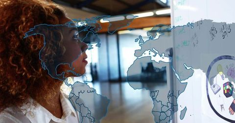 Businesswoman strategizing with global map and diagrams in modern office