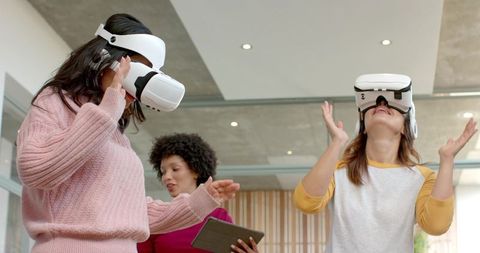 Diverse female coworkers testing vr headsets for collaboration and training in office