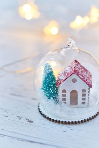Miniature holiday scene in glass orb with snow and lights