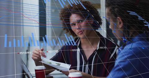 Colleagues analyzing financial data with digital charts overlay