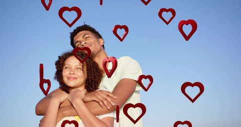 Interracial Couple Embracing with Floating Heart Motifs