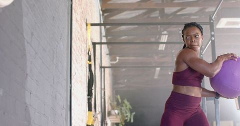 Woman Exercising with Medicine Ball in Gym Focusing on Fitness