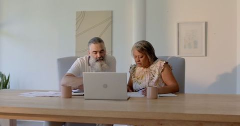 Senior Couple Analyzing Finances on Laptop at Home