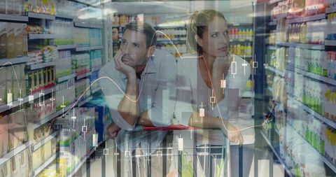 Couple shopping in supermarket with financial overlay showing consumer spending trends