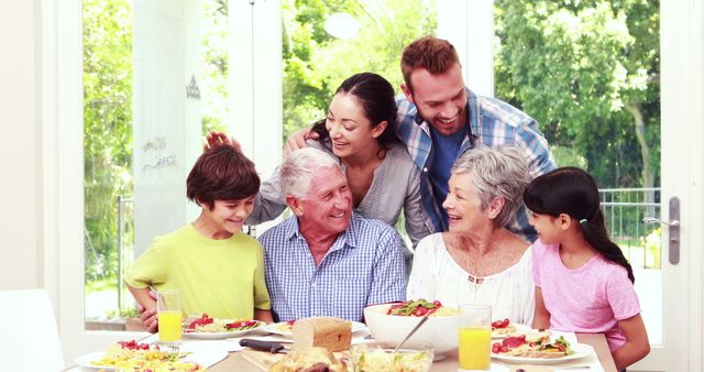 Happy Family Gathering Around Dining Table Enjoying Meal - Download Free Stock Images Pikwizard.com