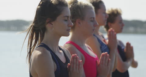 Rowing Team Meditating by Riverside