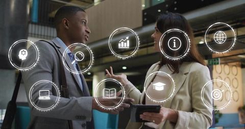 Executives discussing digital strategy in modern atrium with holographic business icons