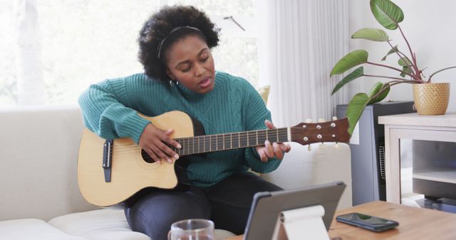 Woman Playing Acoustic Guitar While Watching Tutorial on Tablet - Download Free Stock Images Pikwizard.com