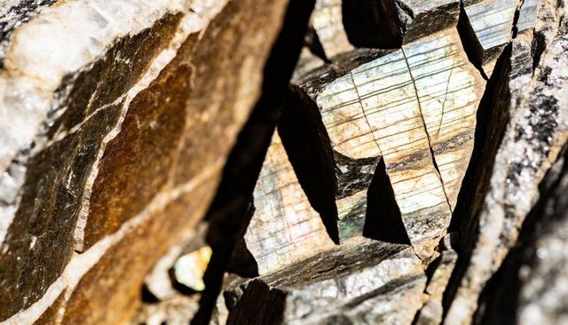 Iridescent labradorite fracture macro showing green blue gold striations and crystal facets