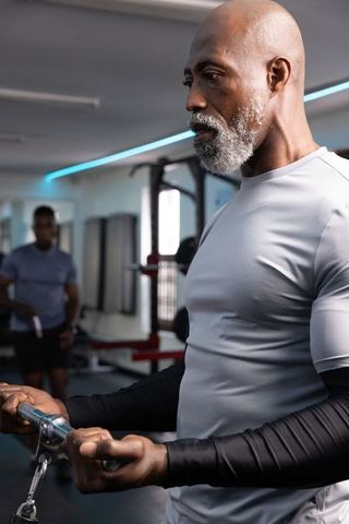 Senior african american man training on cable machine wearing compression top