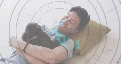 Smiling man hugging small brown dog on carpet with holographic binary overlay for home