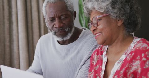 Senior Couple Engaged on Laptop at Home
