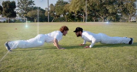 Cricket Players Doing Push-Ups Partner Training on Grass Field
